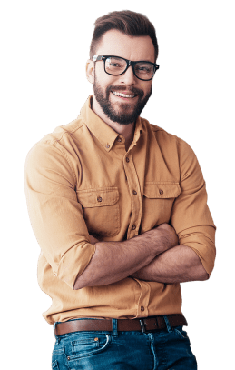 A man with a beard and glasses stands with his arms crossed. He is smiling and wearing a tan button-up shirt with two chest pockets and blue jeans. His hair is neatly styled, and he looks relaxed and confident against a white MINI backdrop.