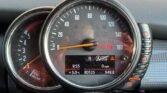 Close-up of a Mini Cooper's dashboard showing dual dials. The left dial displays up to 8000 RPM, while the right one shows speeds up to 160 mph. The digital display indicates 9:53, 5.0°C, 80325 miles, and 0 mph, along with various warning indicators and the "Auto Start Stop" symbol in this Diesel 5-D