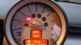 Close-up of a MINI COOPER's dashboard in morning light. The speedometer reads 2 RPM x 1000 and includes warning lights. The digital display shows the time as 08:52, temperature as +9.0°C, remaining range as 46 miles, trip distance as 469.3 miles, and total mileage at 118,688.