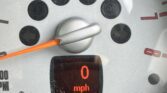 A close-up of a mini car speedometer shows 0 mph. The digital display reads +17.5°C, 045807 miles, and 262.8. The needle rests at zero, with minor dust and smudges visible on the dashboard glass.