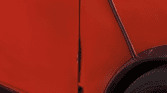 Close-up of a red mini car showing the front side door and wheel. The door is misaligned with a visible dent and gap near the hinge. It has a white side mirror, black trim, and part of the gray wheel rim is seen on a paved road.