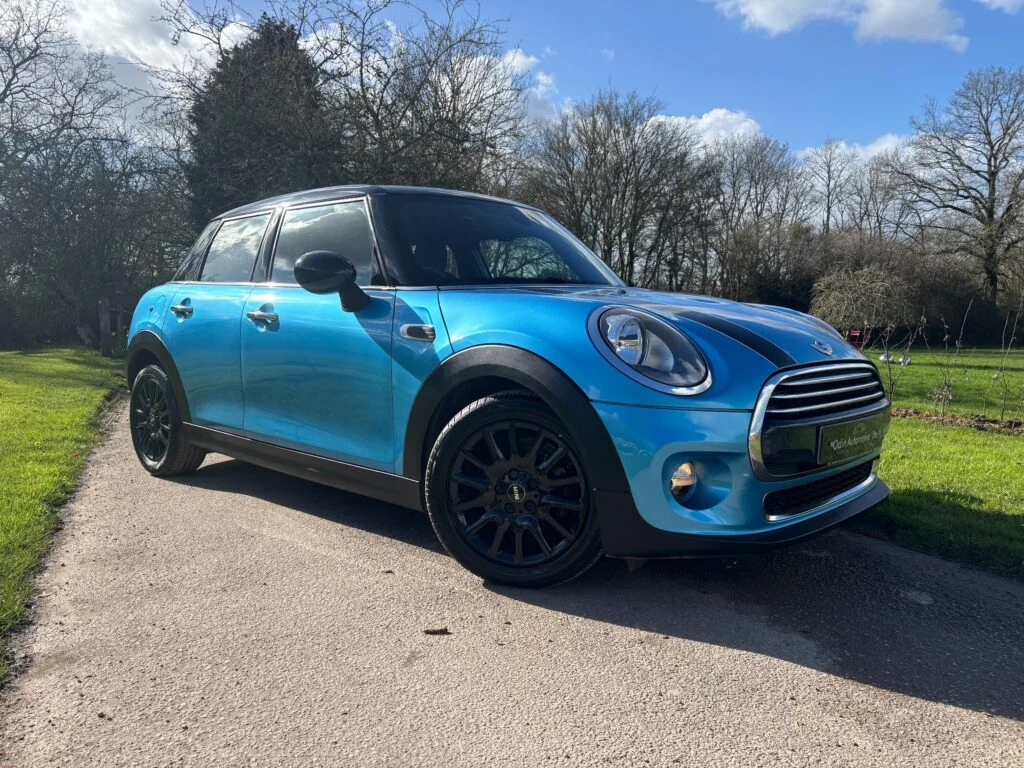 A MINI Cooper hatchback parked on a UK street, weighing up petrol vs diesel for used buyers